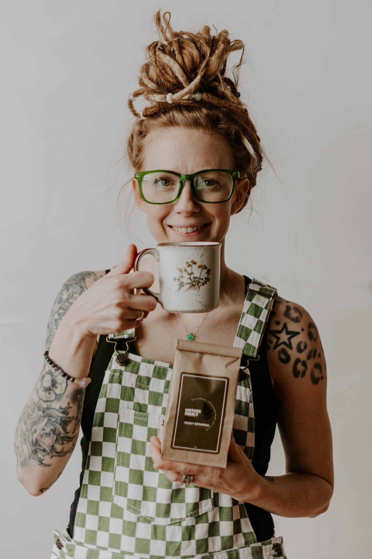 dreadlocks, girl with dreadlocks, green overalls, checkered overalls, green and white, crystals in hair, vintage mug, tea cup, mother freely, tea, herbal tea, hot tea, loose leaf, crystal bracelet, tattoos